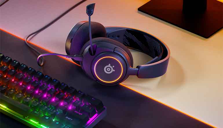 SteelSeries Arctis Nova 3 Review: the headset lies on a desk next to a keyboard.