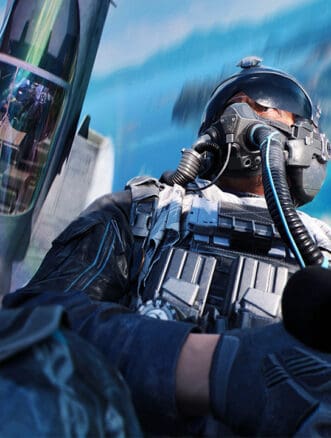 Fighter pilot wearing helmet and gear in cockpit with jet and ocean view.